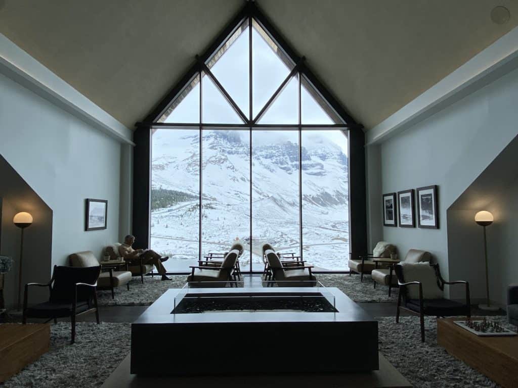 Lounge at Glacier View Lodge with view of Athabasca Glacier from large window.