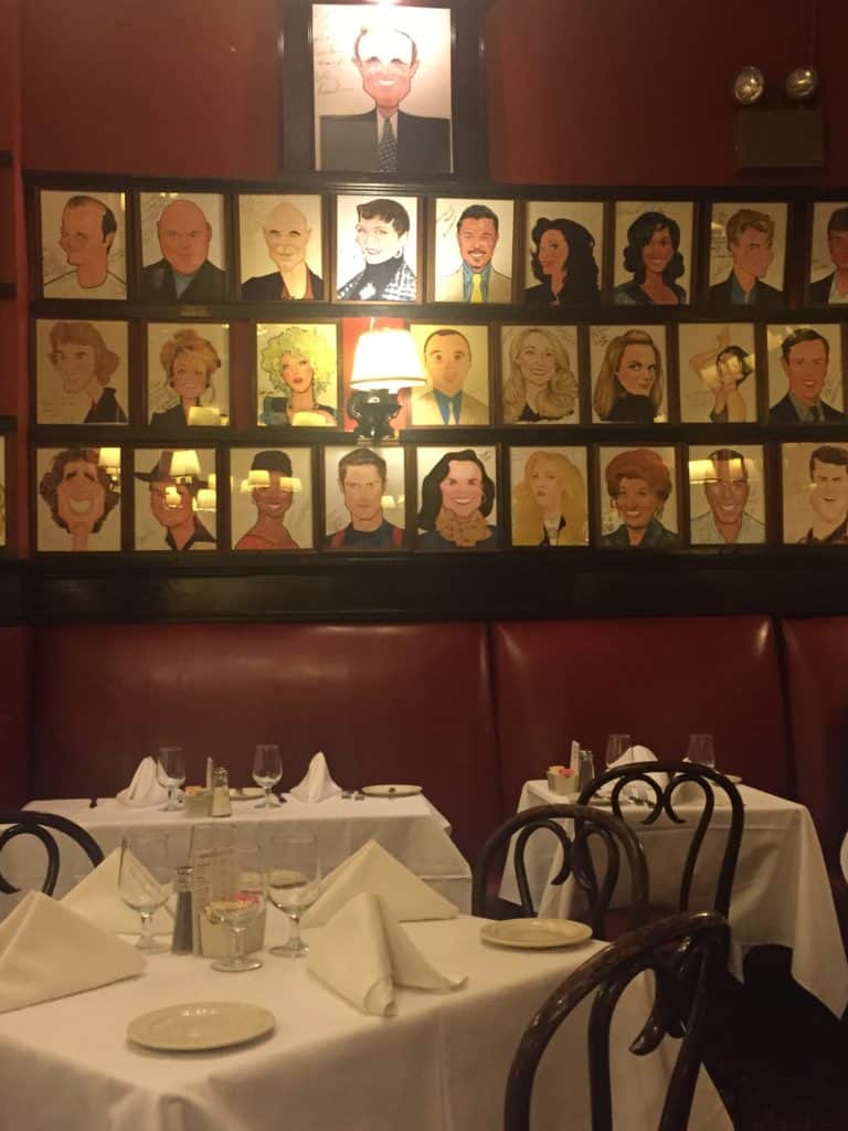 Interior of Sardi's Restaurant in New York City with frames caricatures of show business people on wall.