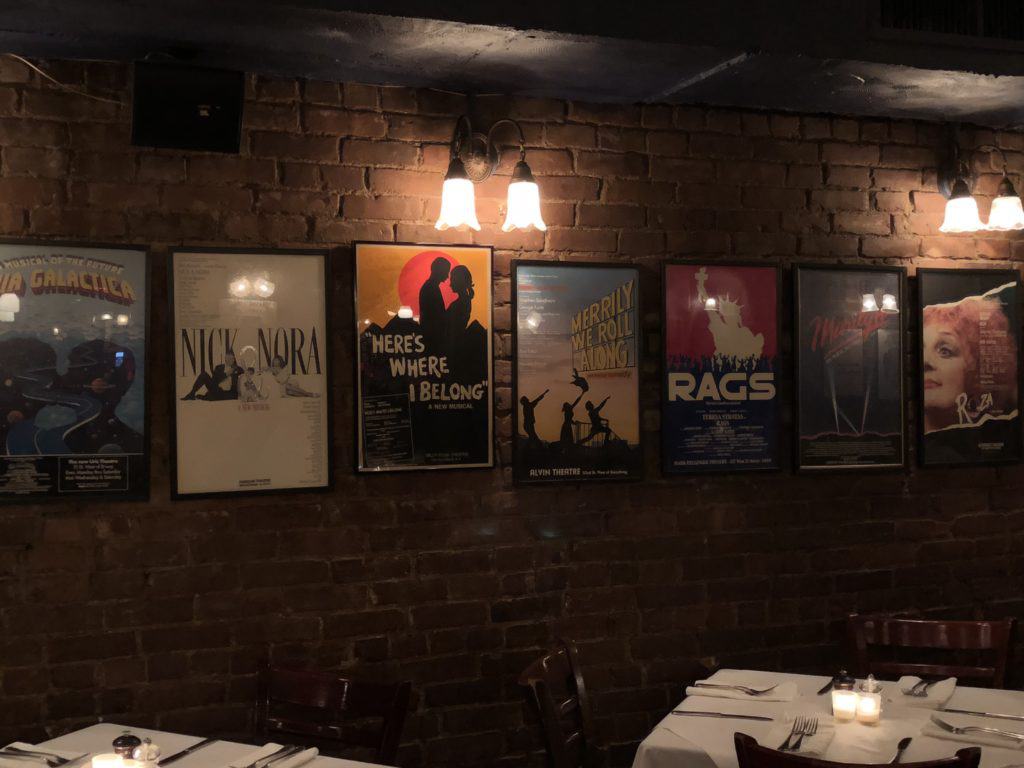 Interior of Joe Allen Restaurant in New York City with show posters on wall.