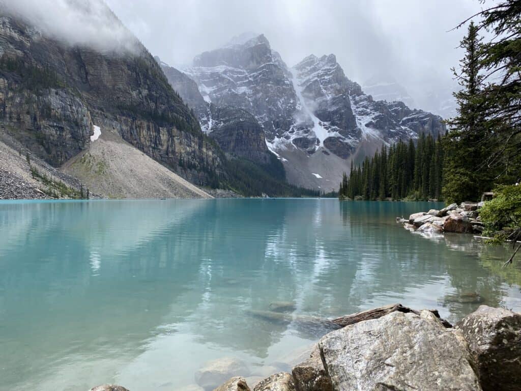 Snow-capped mountains and reflection in blue waters of Moraine Lake in Banff National Park, Alberta, Canada.