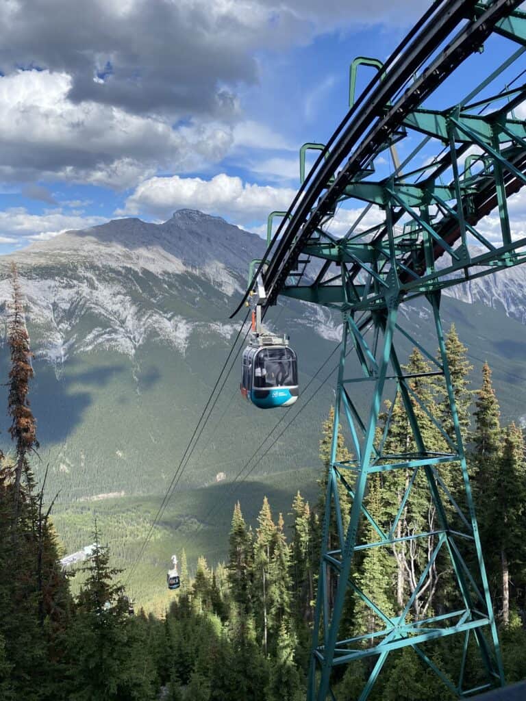 Banff Gondola carriages coming up to the station with mountains in background.