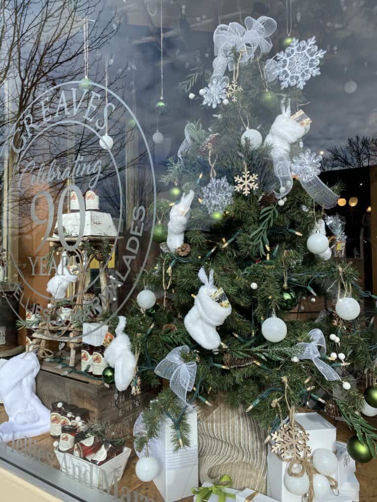 Christmas tree and display with white ornaments in window of Greaves in Niagara-on-the-Lake.