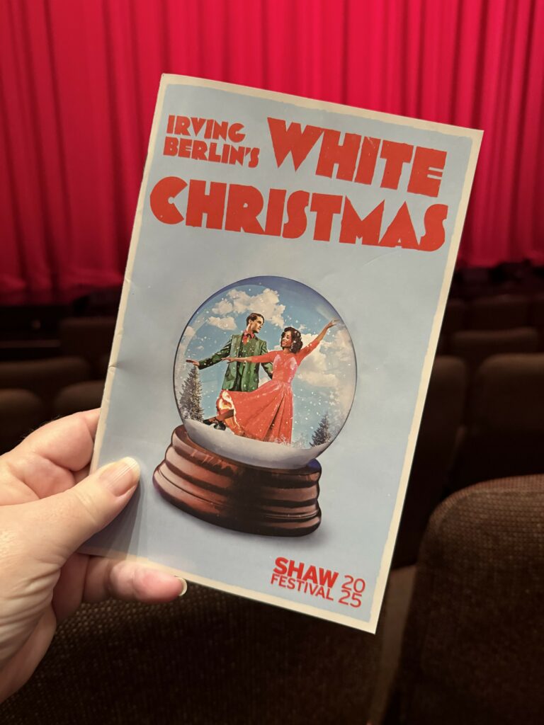 Shaw Festival program for Irving Berlin's White Christmas with red stage curtain in background.