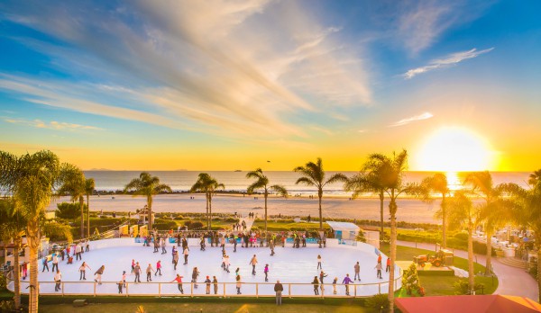 People skating on rink on the beach at Hotel del Coronado while sun is setting in San Diego, California.