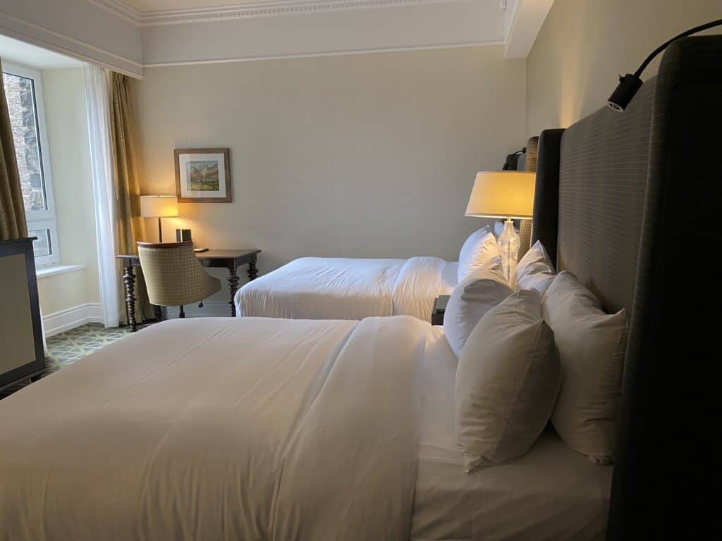 Two beds, chair and desk in room at the Fairmont Banff Springs Hotel in Banff, Alberta, Canada.