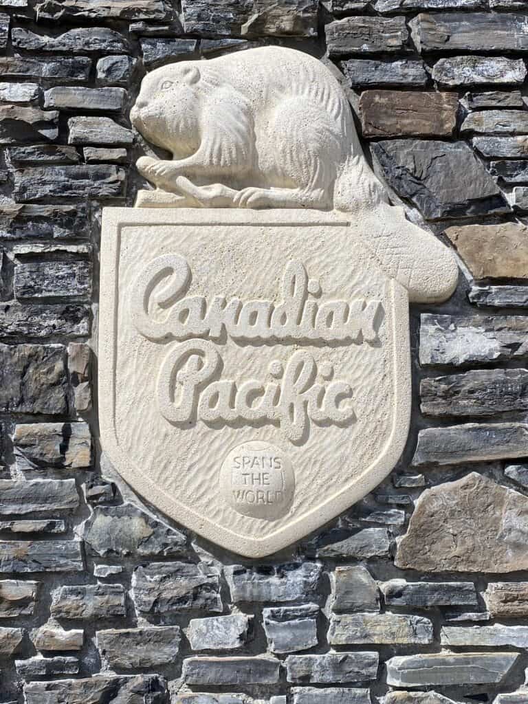 Canadian Pacific logo embedded in grey stone of hotel - shield with beaver on top.