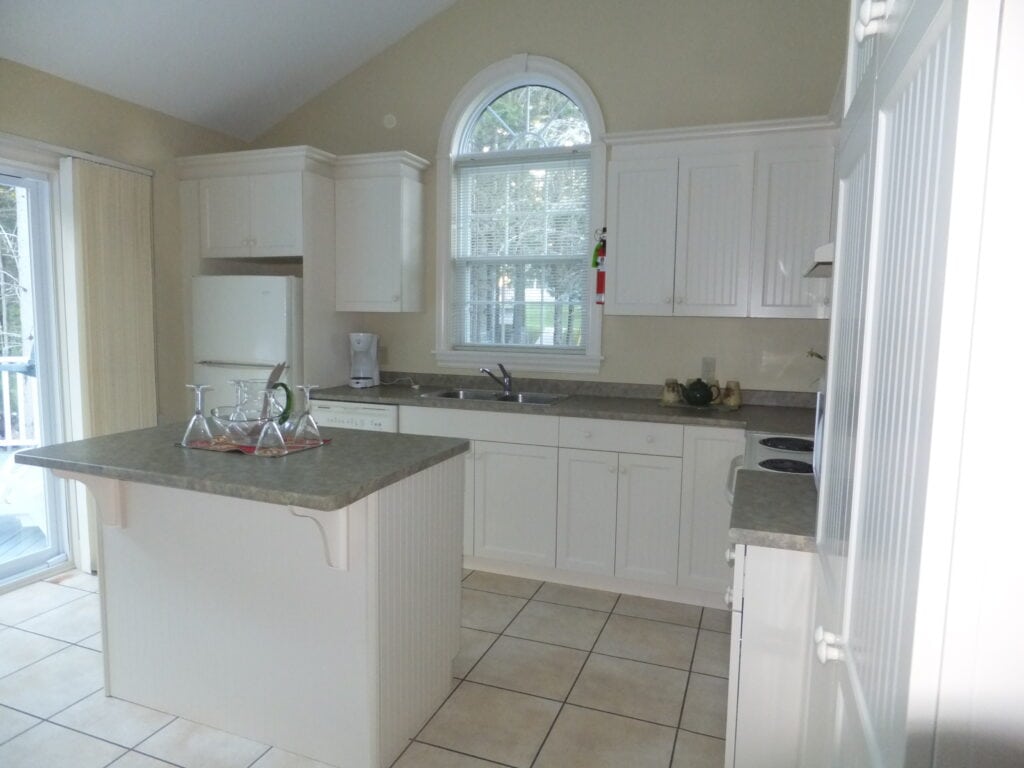 White kitchen with small island - Kindred Spirits 3 bedroom cottage.