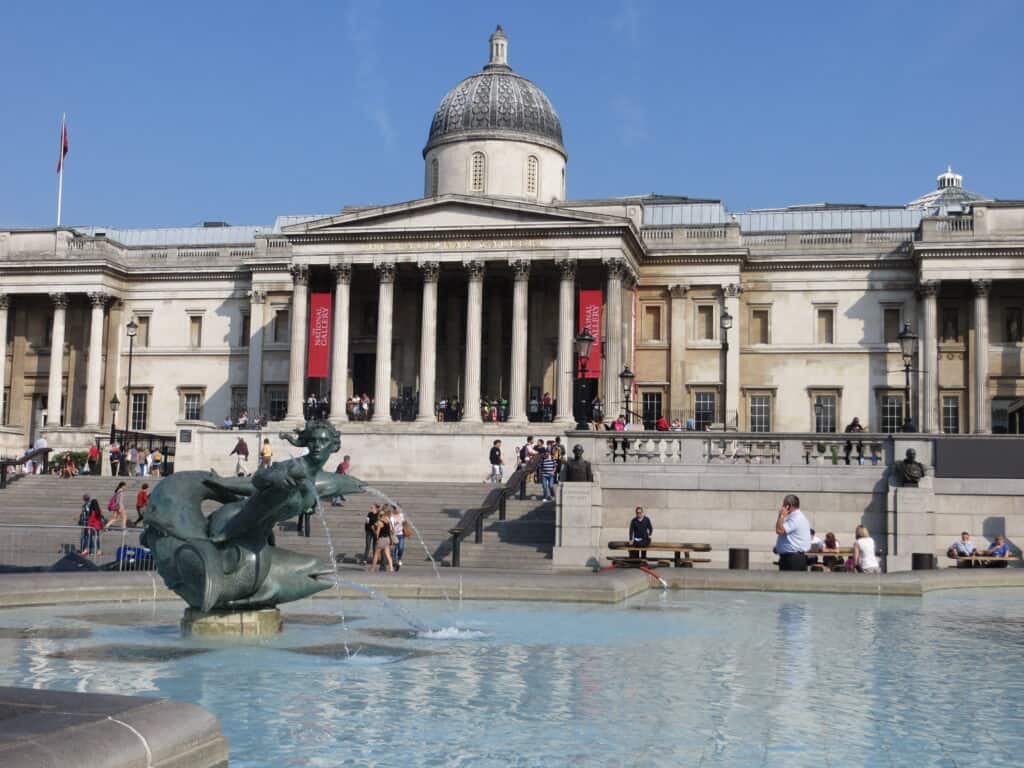 Fountain in Trafalgar Square, London with the National Gallery in the background.