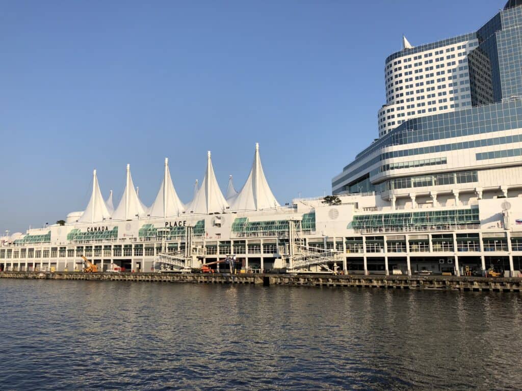 Buildings and white sails of Canada Place along waterfront in Vancouver, British Columbia.