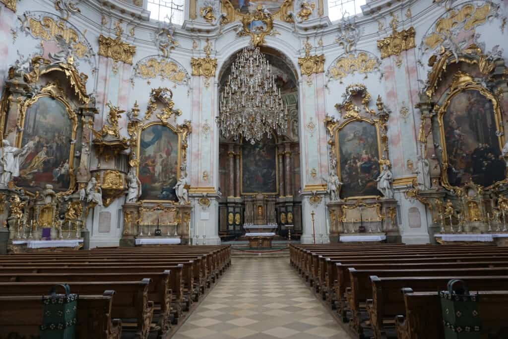 Elaborate interior of the Ettal Monastery - pews and aisle to the front of church.