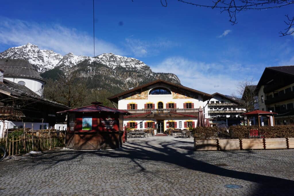 Buildings in Garmisch-Partenkirschen on a beautiful early spring day - bright blue sky with a few wispy white clouds and snow-topped mountain peak in background.