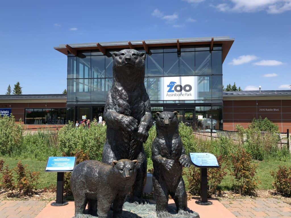 Sculpture of adult bear and two cubs in front of the entrance to Assiniboine Park Zoo in Winnipeg, Manitoba.