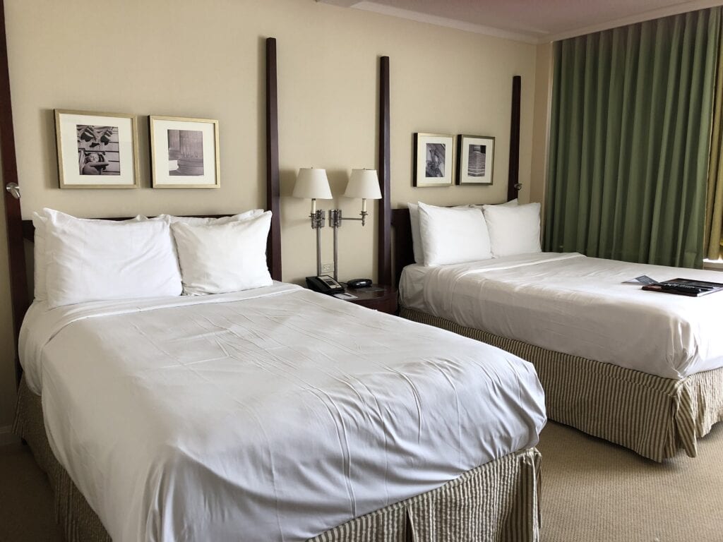 Fairmont Winnipeg hotel room - two double beds, beige walls, two framed photographs above each bed.