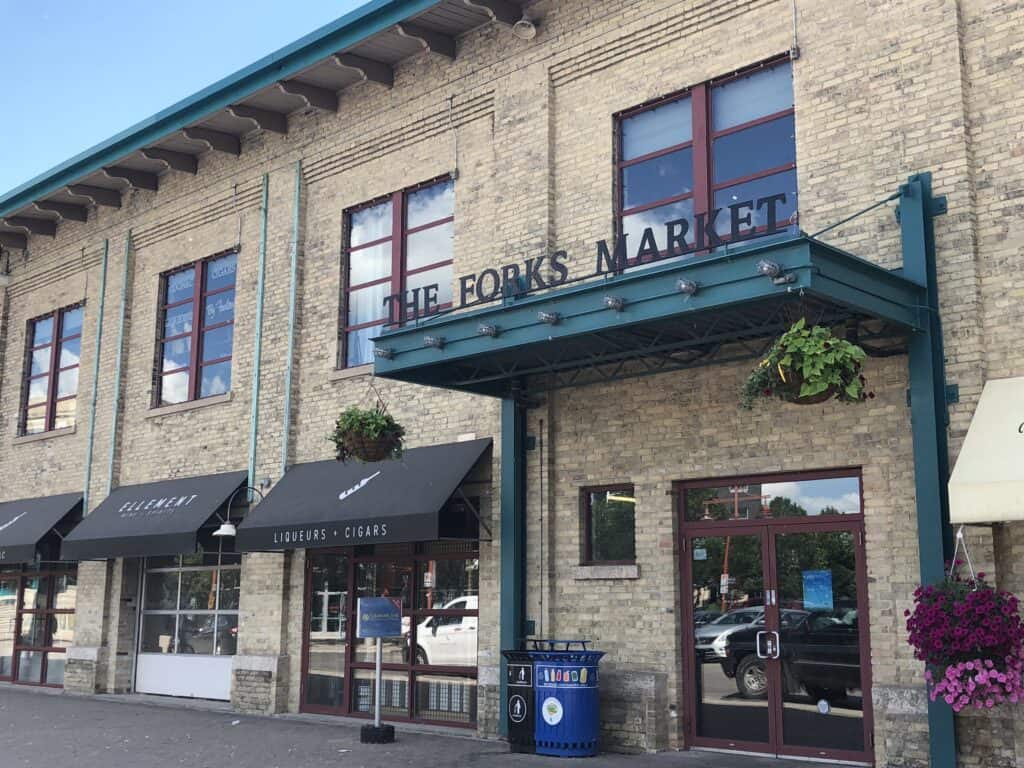 Entrance to The Forks Market in Winnipeg - brown brick building with black awnings.