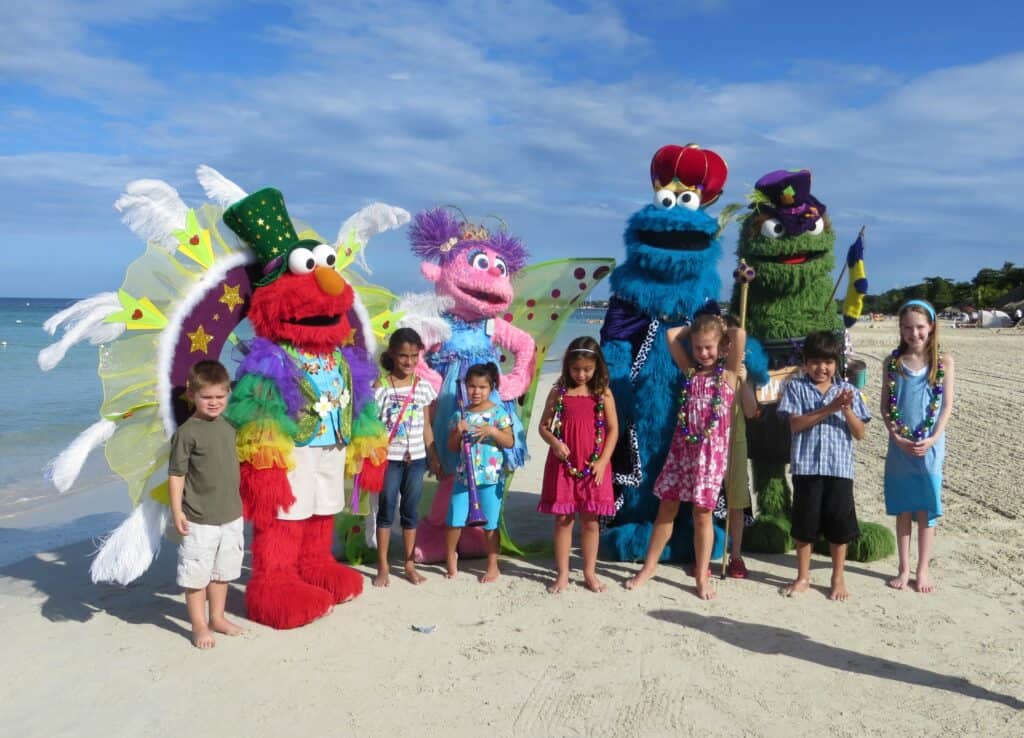 Group of children posing on beach with Sesame Street characters - Beaches Resort Negril, Jamaica.