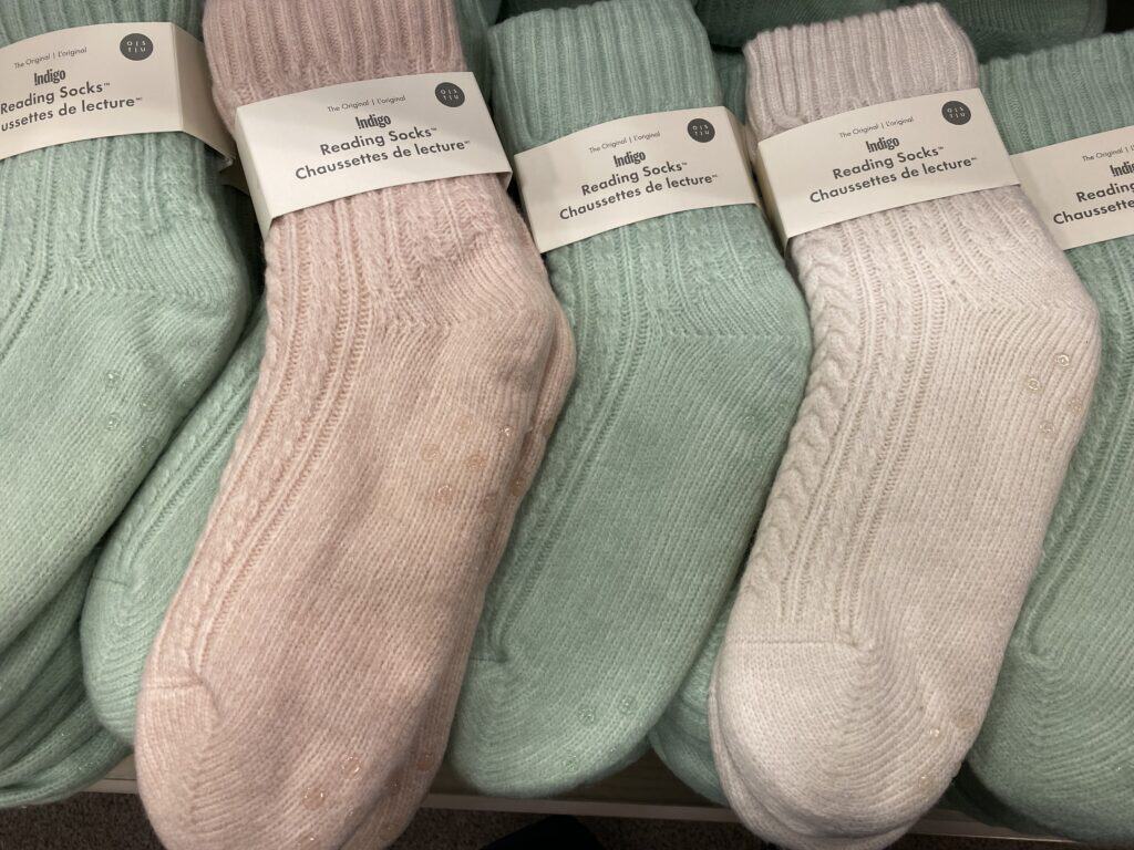 Display of pale pink, mint green and cream coloured reading socks at Indigo.