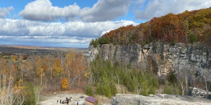View of Niagara Escarpment at Kelso Conservation Area in fall with orange and yellow leaves.