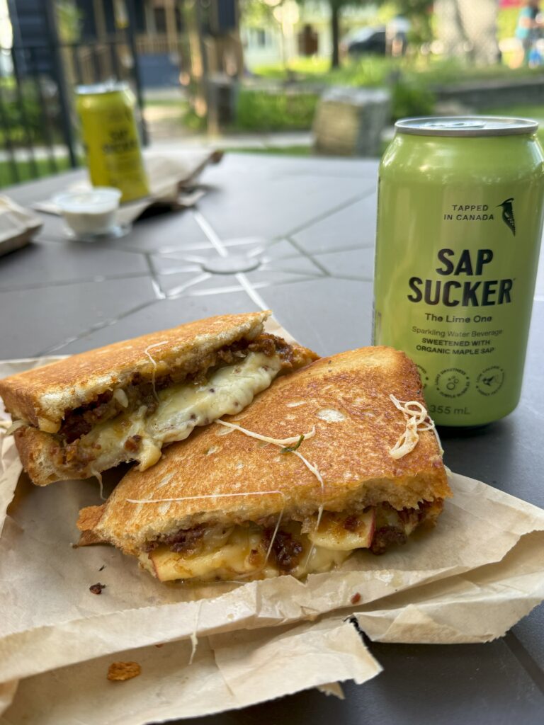 gourmet grilled cheese and green sap sucker can on table at that's what cheese said in Kagawong on Manitoulin Island.