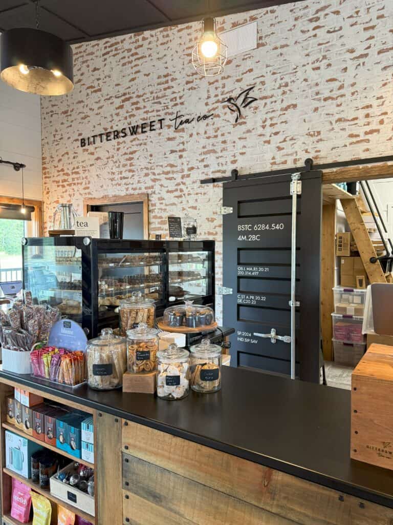 Counter display with stone wall in the background and Bittersweet tea co. logo on the wall - M'Chigeeng on Manitoulin Island.