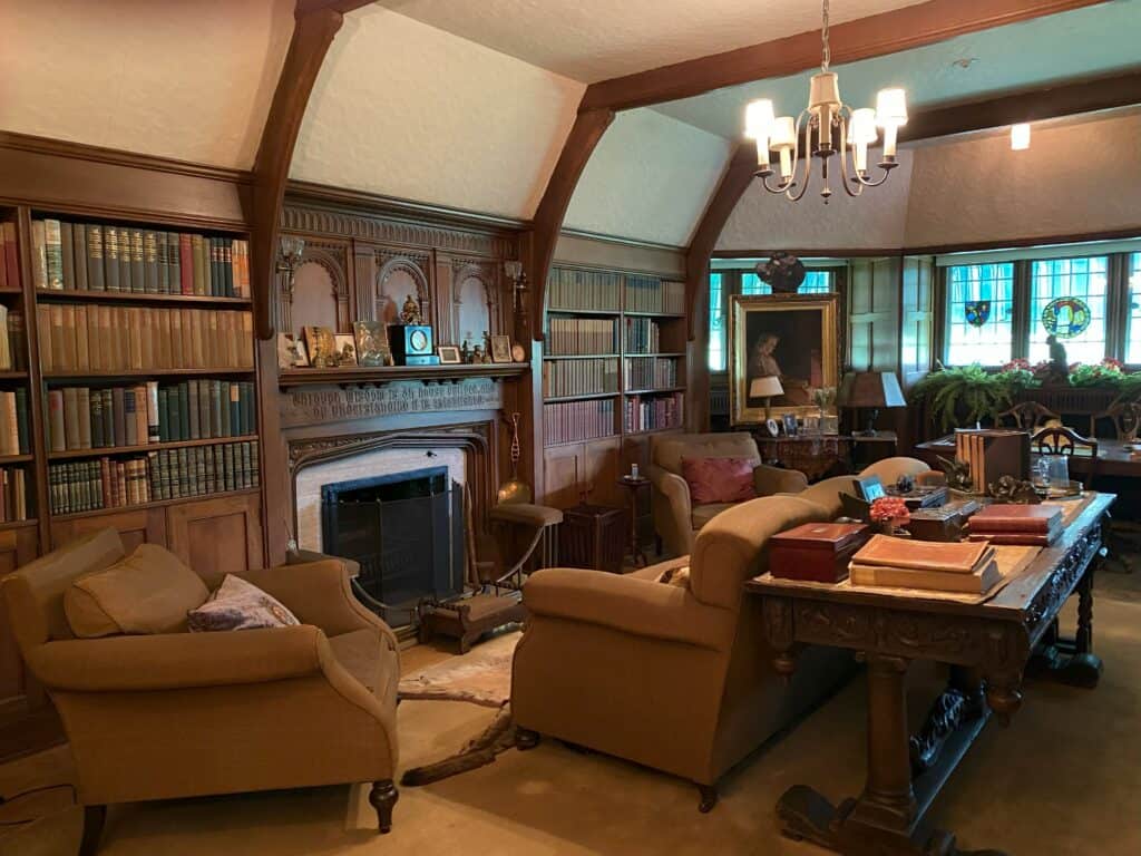 Room at Laurier House National Historic Site - dark brown furniture, fireplace, books shelves on both sides.