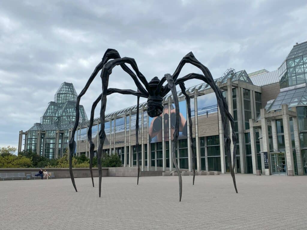 'Maman' - large bronze sculpture of a spider in front of the National Gallery of Canada on an overcast day.