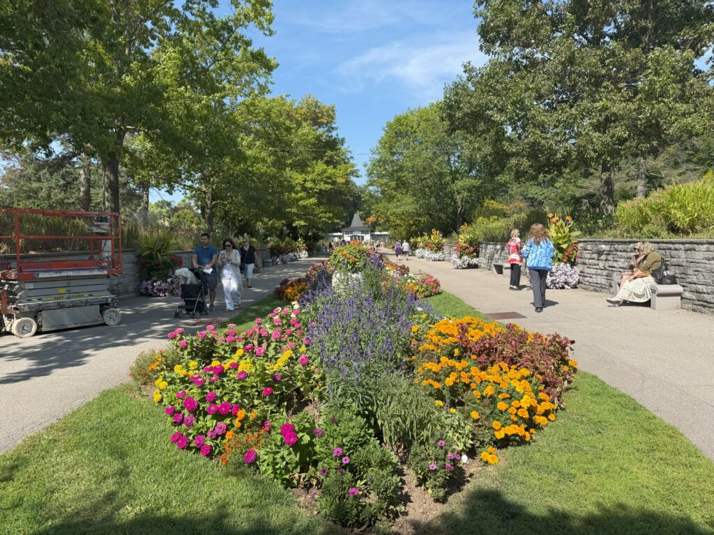 People strolling along both sides of colourful garden in Hendrie Park at the Royal Botanical Gardens.