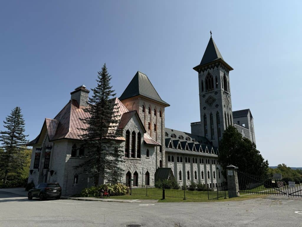 exterior of Abbaye de Saint-Benoit-du-Lac in the Eastern Townships of Quebec - grey stone with copper roofing.