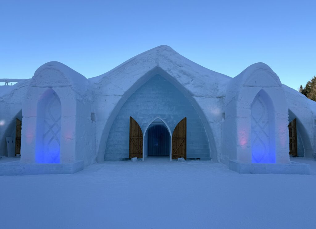 exterior of quebec city ice hotel with bright blue sky.