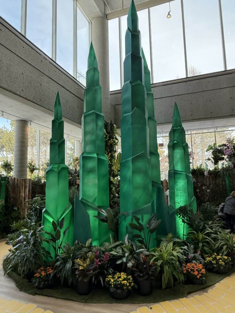 tall emerald columns surrounded by foliage and flowers.