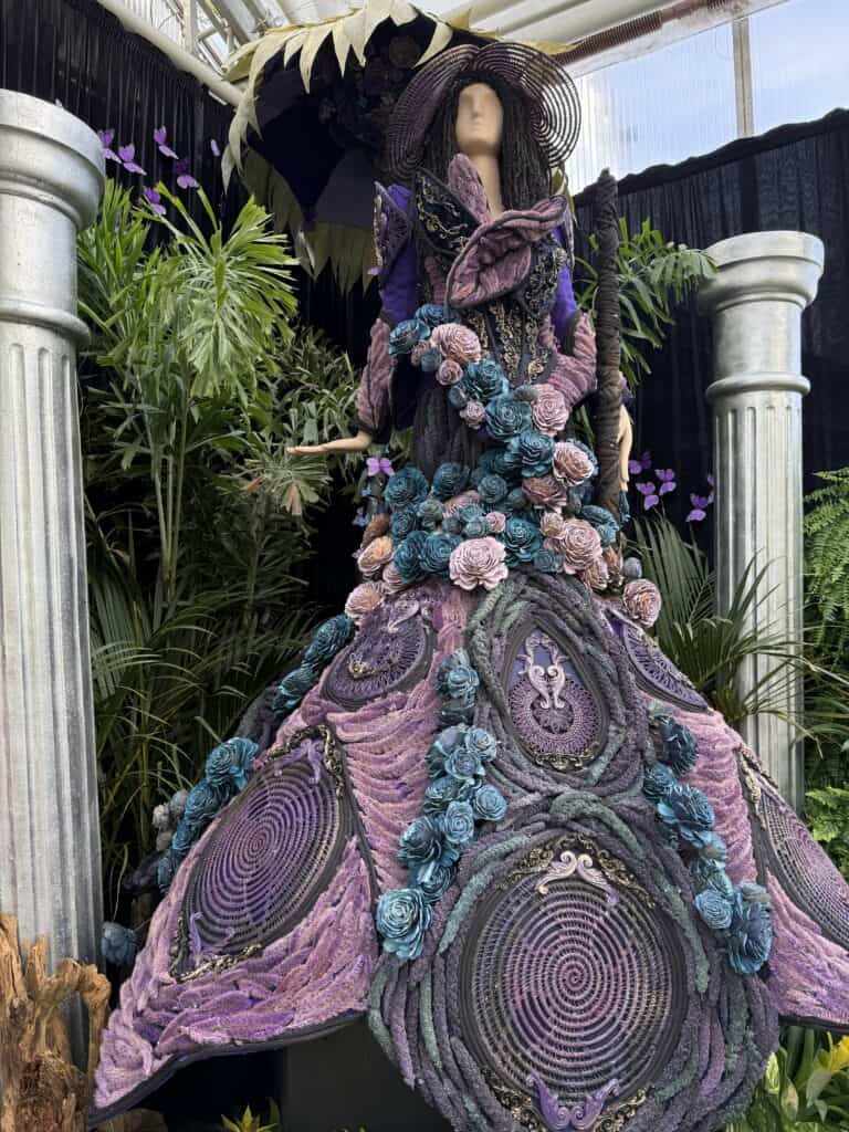 mannequin wearing floral gown in shades of purple and darker blues.