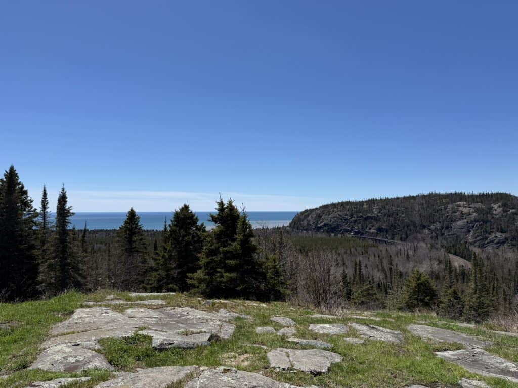 scenic lookout in Marathon on Lake Superior Circle Tour - Canadian shield, evergreen trees, lake in background and clear blue sky.