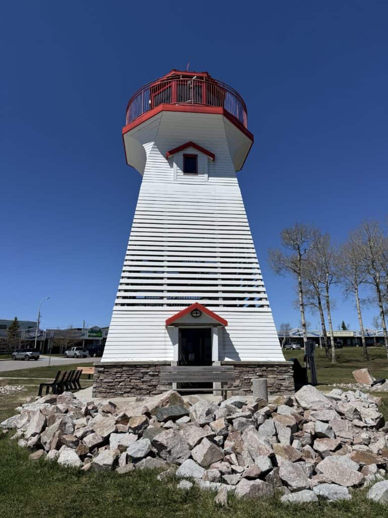 white lighthouse with red trim and a bright blue sky