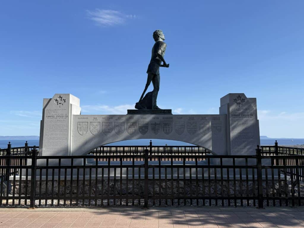 bronze statue and monument of Terry Fox near Thunder Bay with bright blue sky.