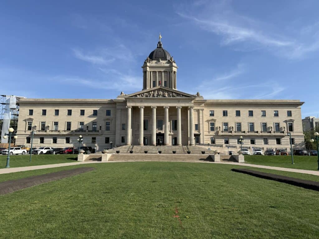 manitoba legislative building set against bright blue sky with a few wispy white clouds