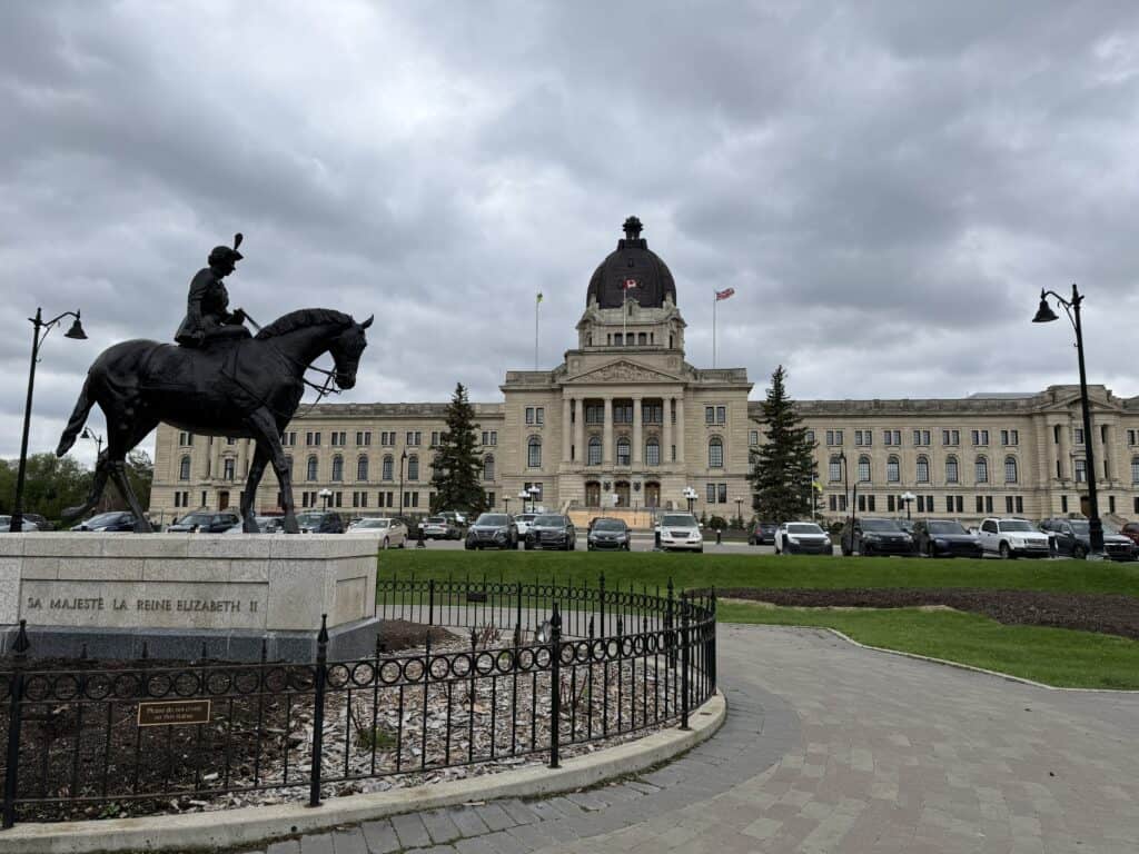 statue of Queen Elizabeth II on horseback with Saskatchewan Legislative building in background on overcast day.