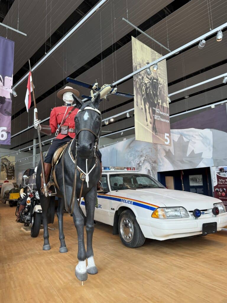 display at RCMP Heritage Centre with uniformed rider and horse and police car in foreground.