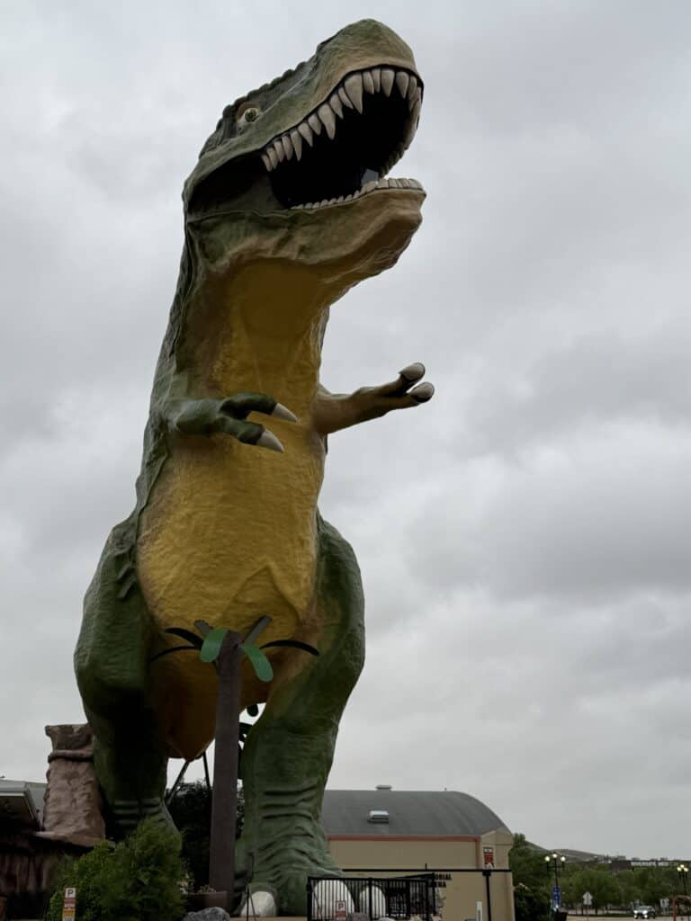 large dinosaur sculpture in Drumheller on overcast day.