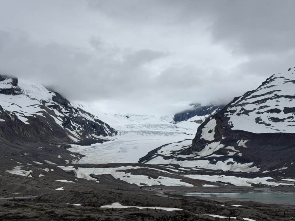 Athabasca Glacier between snow capped mountains.