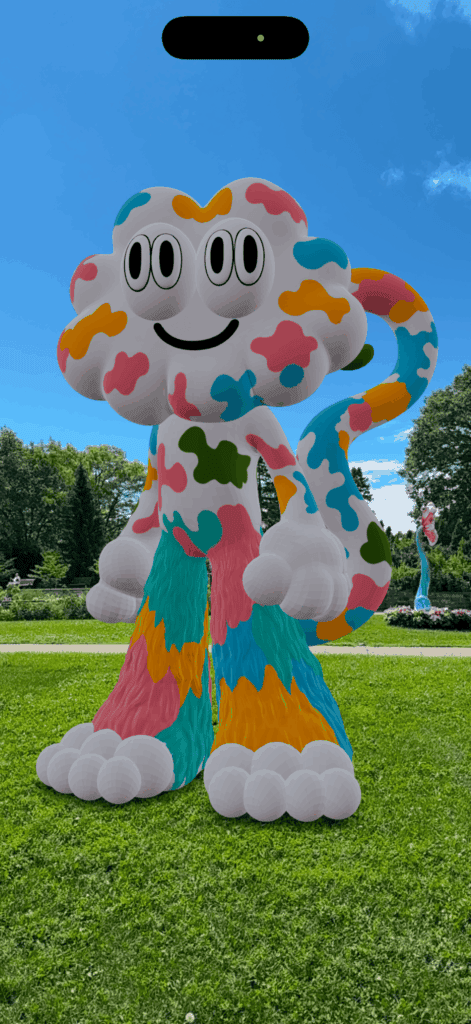 screenshot of colourful anchorball augmented reality character in gardens against bright blue sky.