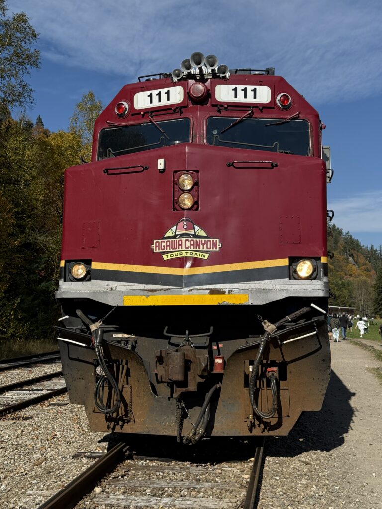 dark red train engine with agawa canyon tour train logo on front.