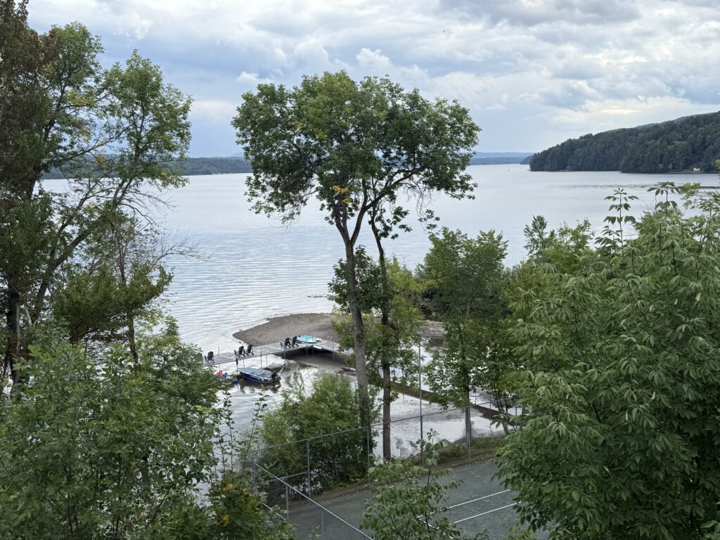 view of lake and dock through trees at manoir hovey.